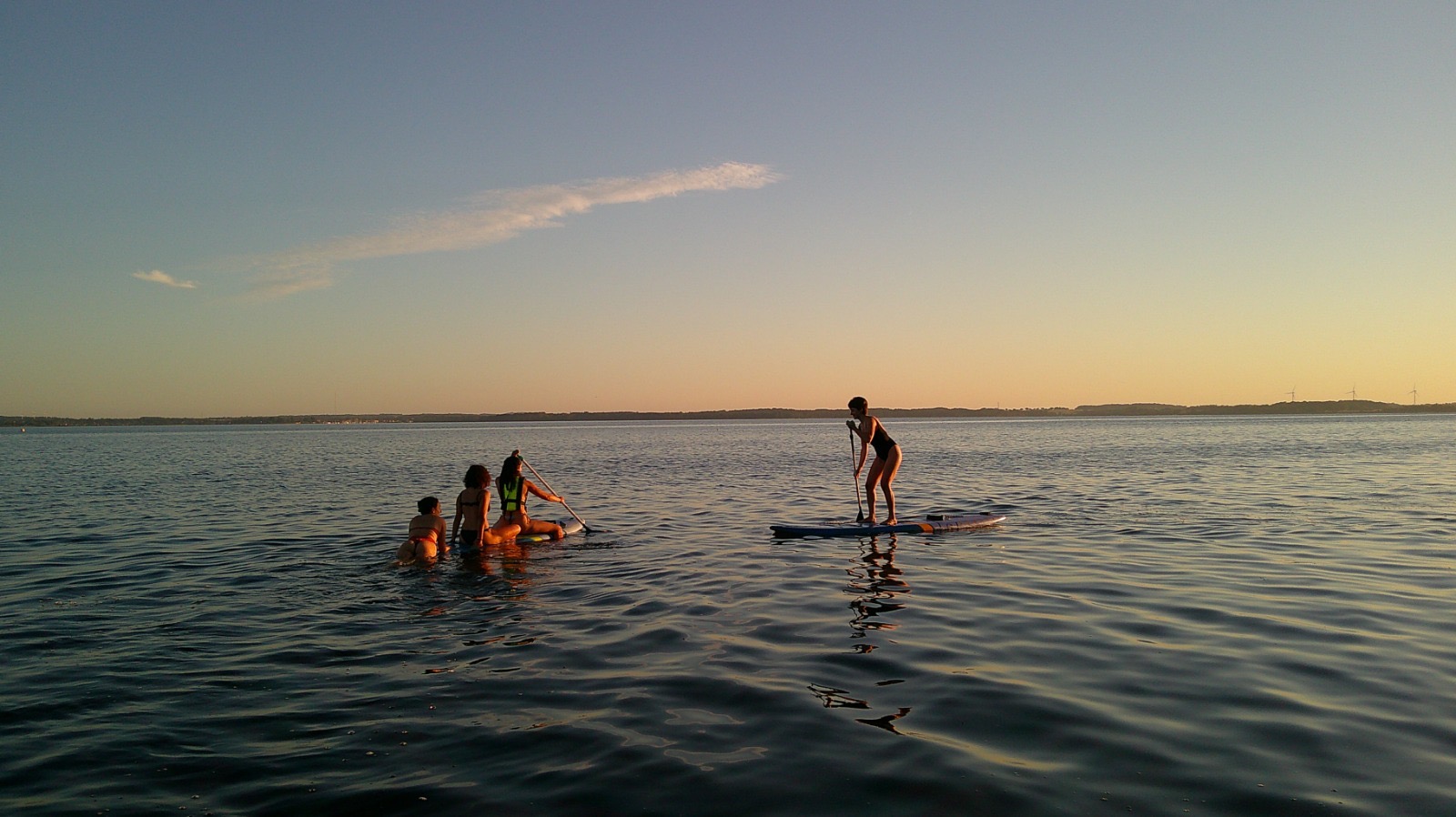 A group of volunteers spending an evening together on a dock by the water