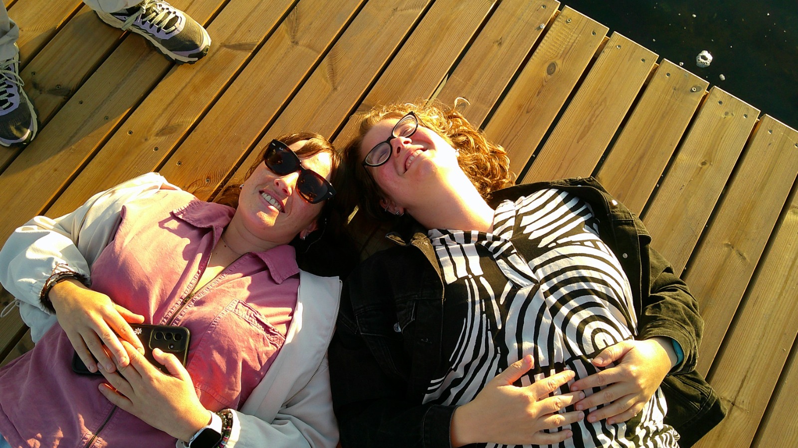 Volunteers relaxing on a dock and looking out across the water