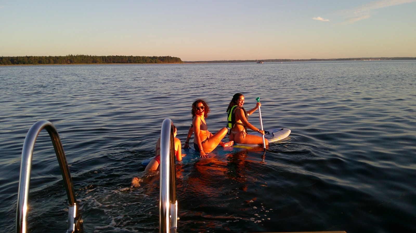 A group of volunteers relaxing together on a wooden dock beside the fjord